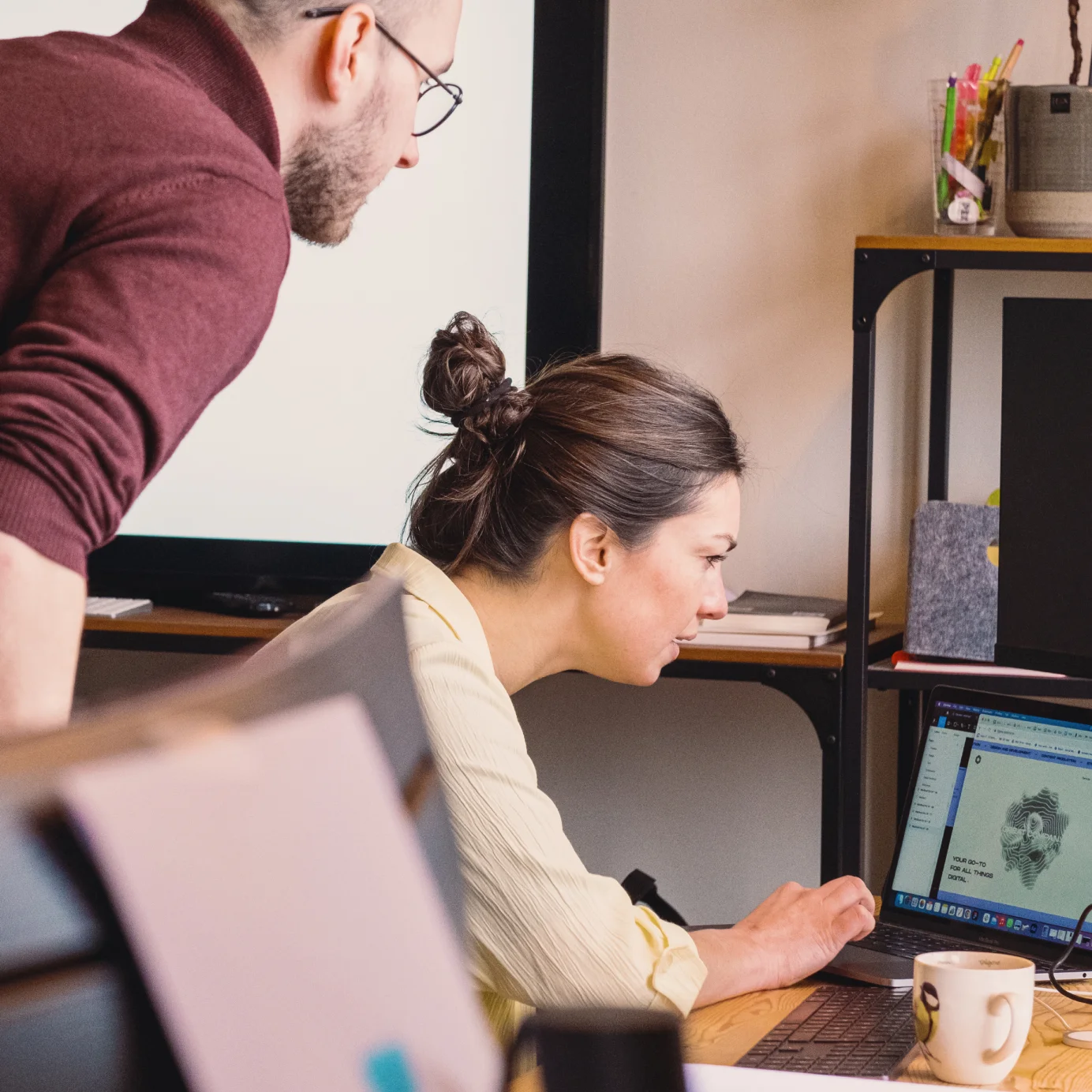 Two colleagues at their desk, figuring out some things