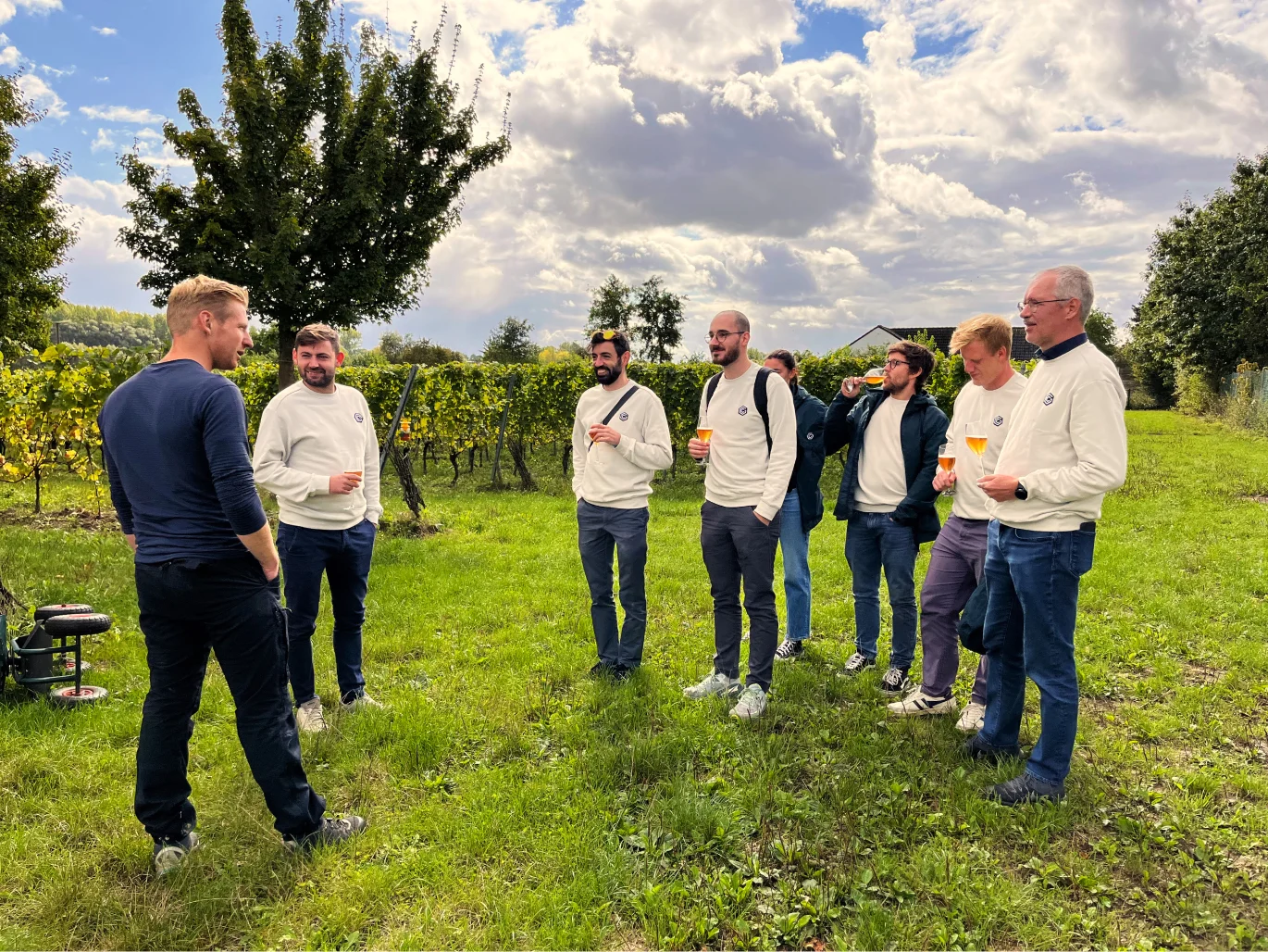 Seven colleagues getting a tour about processing wine at a winery